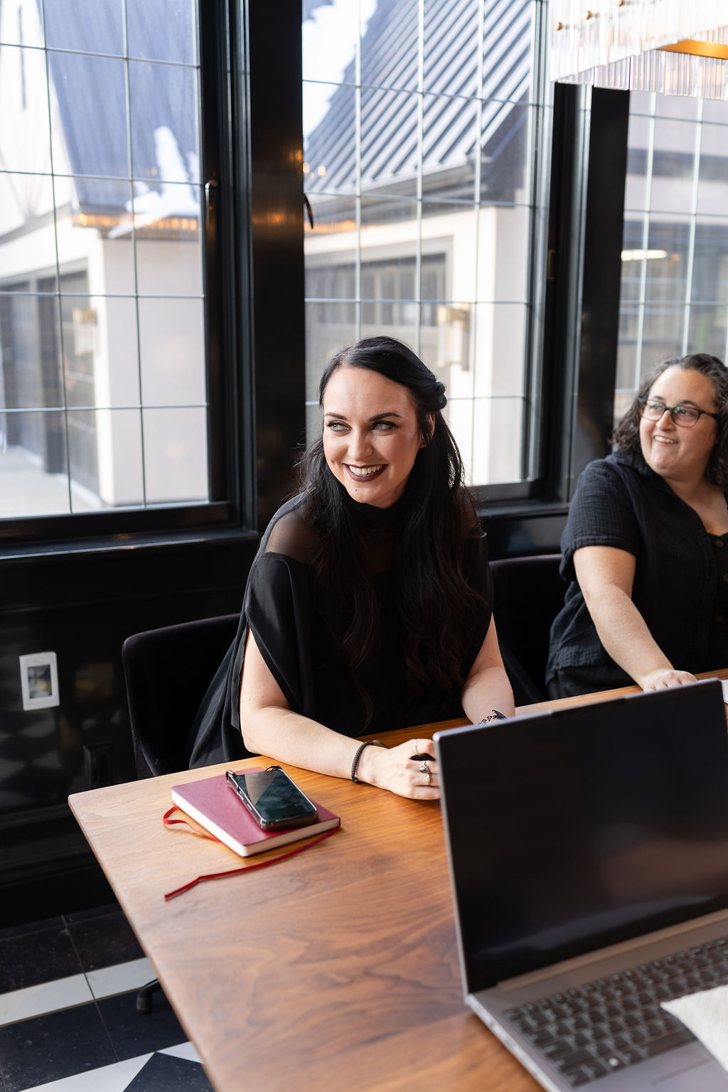 Alt Text: Two marketing professionals collaborating at a laptop during a strategic planning session, highlighting the importance of early preparation and marketing strategy for Black Friday 2026.